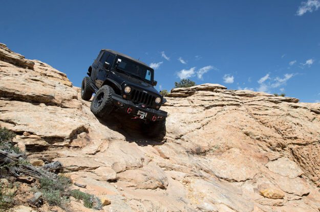 black jeep going down rocks