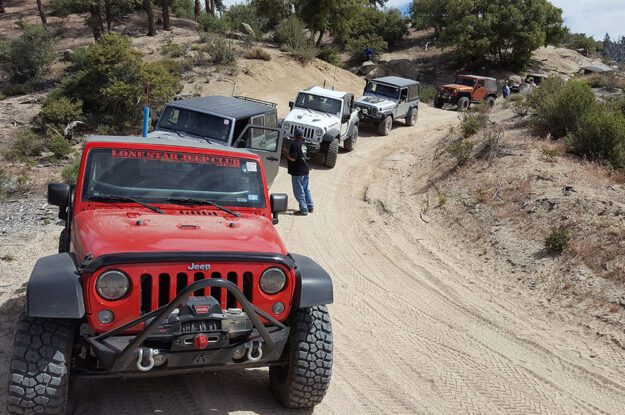 row of jeeps with red jeep