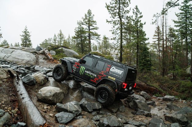Casey Currie's Jeep driving up wet rocks.