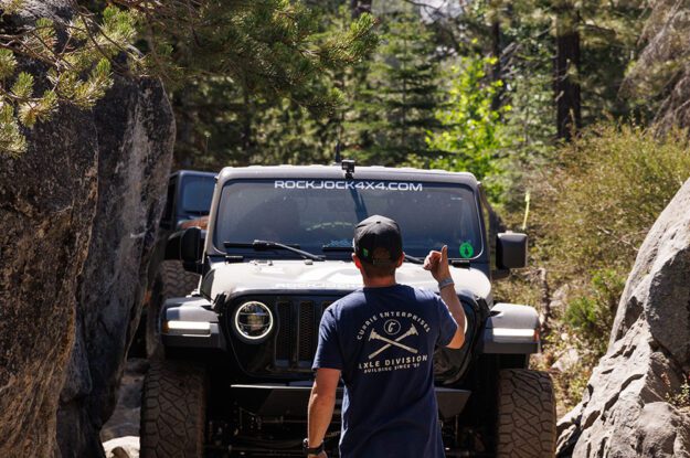 Casey Currie guides Jeep between rocks while another Jeep waits.
