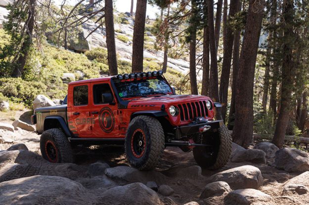 Red Jeep Gladiator on rocks.
