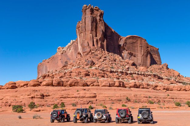 Large rock outcropping and five Jeeps.