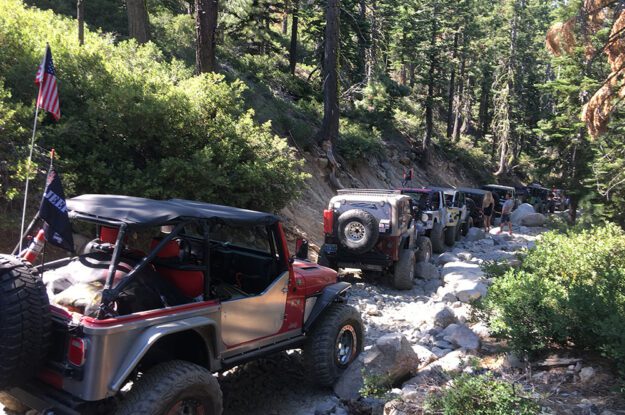 Line of Jeeps drving down a rocky trail.