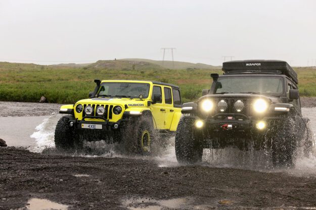 two jeeps crossing stream