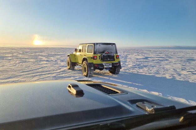two jeeps driving towards horizon