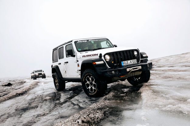 white jeep on slanted hill