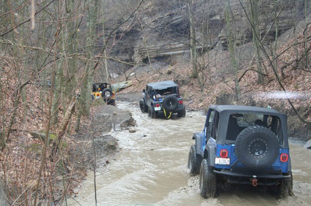 three jeeps on wet road