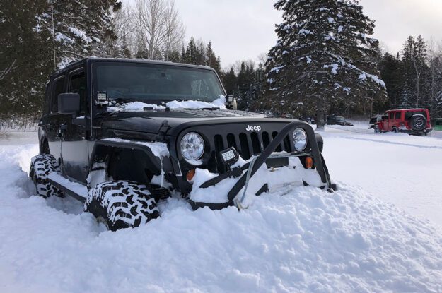 black jeep pushing snow