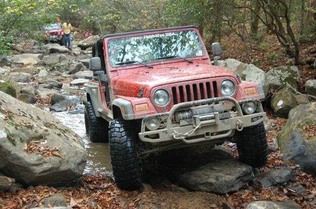 Jeeps driving down rocky stream