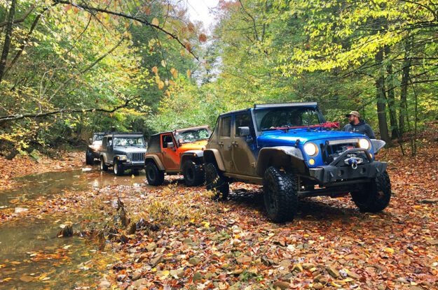 Jeeps driving through stream