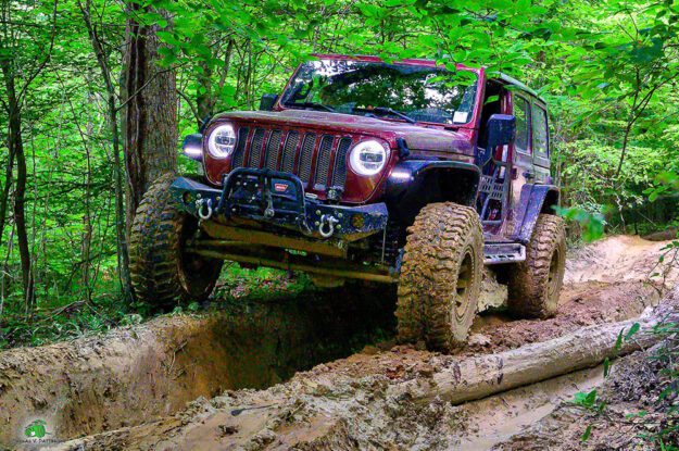 Jeep straddling large rut