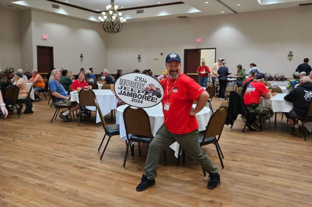 Man posing with 28th annual sign