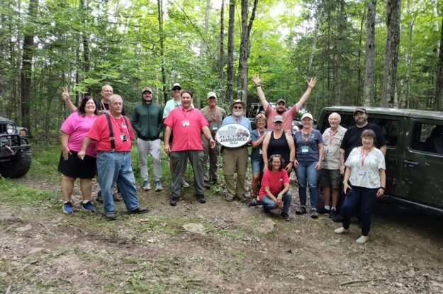 People posing in the woods with 28th annual sign