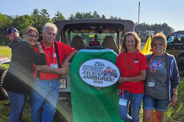 People posing with 28th annual sign