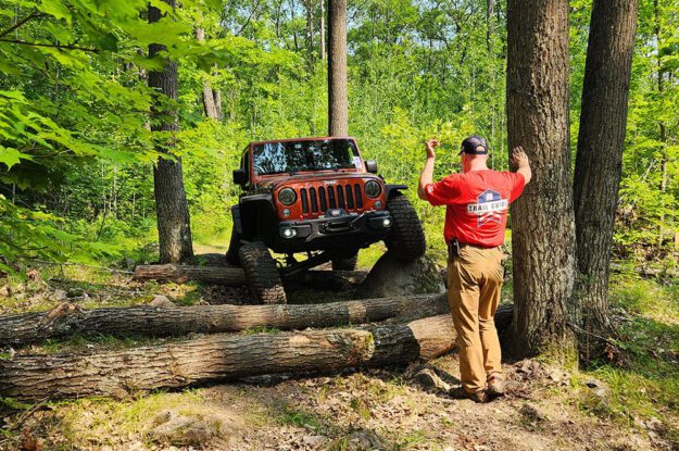 Jeep driving over logs