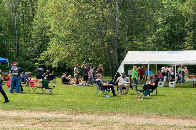 People in chairs on grass talking