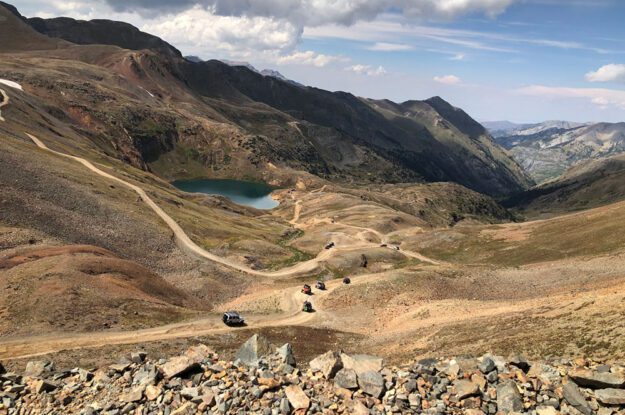 Jeeps descending near a lake