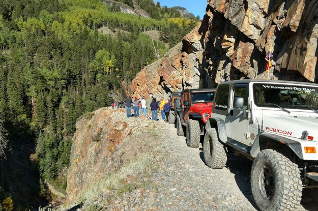 People and jeeps on a cliff edge