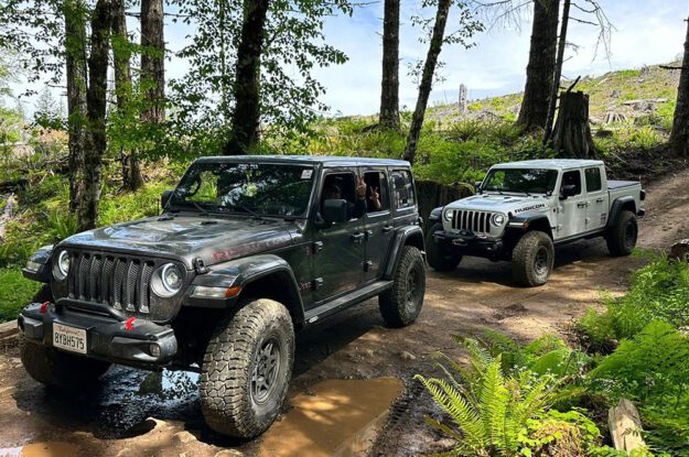 Jeeps on a road with a puddle