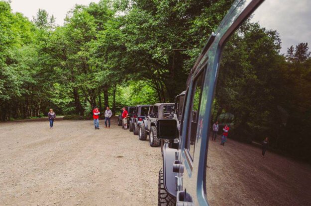 Jeeps lined up in gravel parking lot