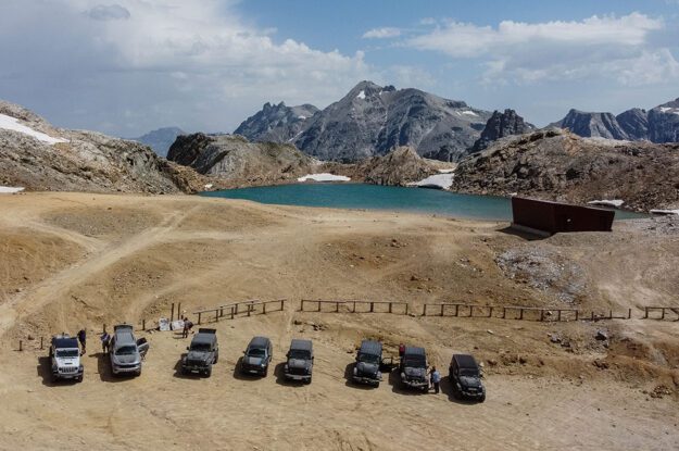 jeeps lined up by lake